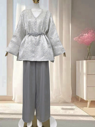 Veste kimono femme argentée et grise à motif brocart, coupe fluide avec manches larges et ceinture grise tressée, portée avec pantalon gris ample.